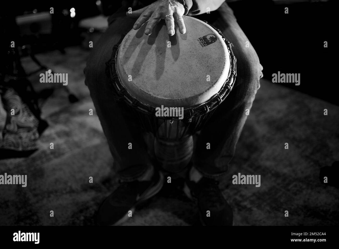 A beautiful grayscale view of Djembe drum player's hand on drum Stock