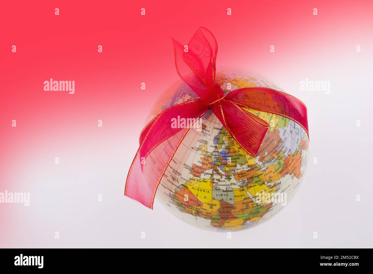 A globe with a ribbon on a red and white background Stock Photo