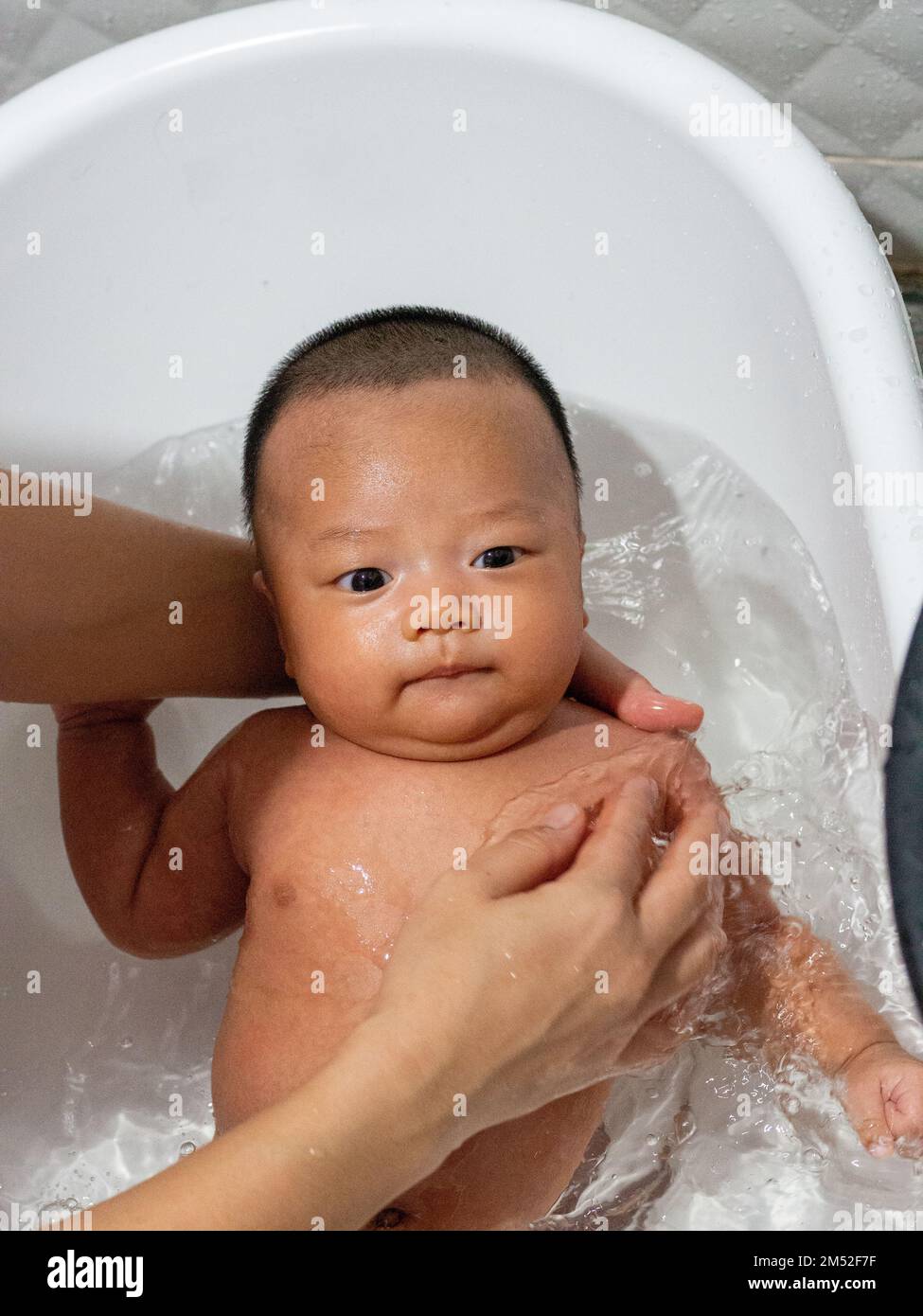 Baby Asian and nationality Thai is bathing in a white basin Stock Photo