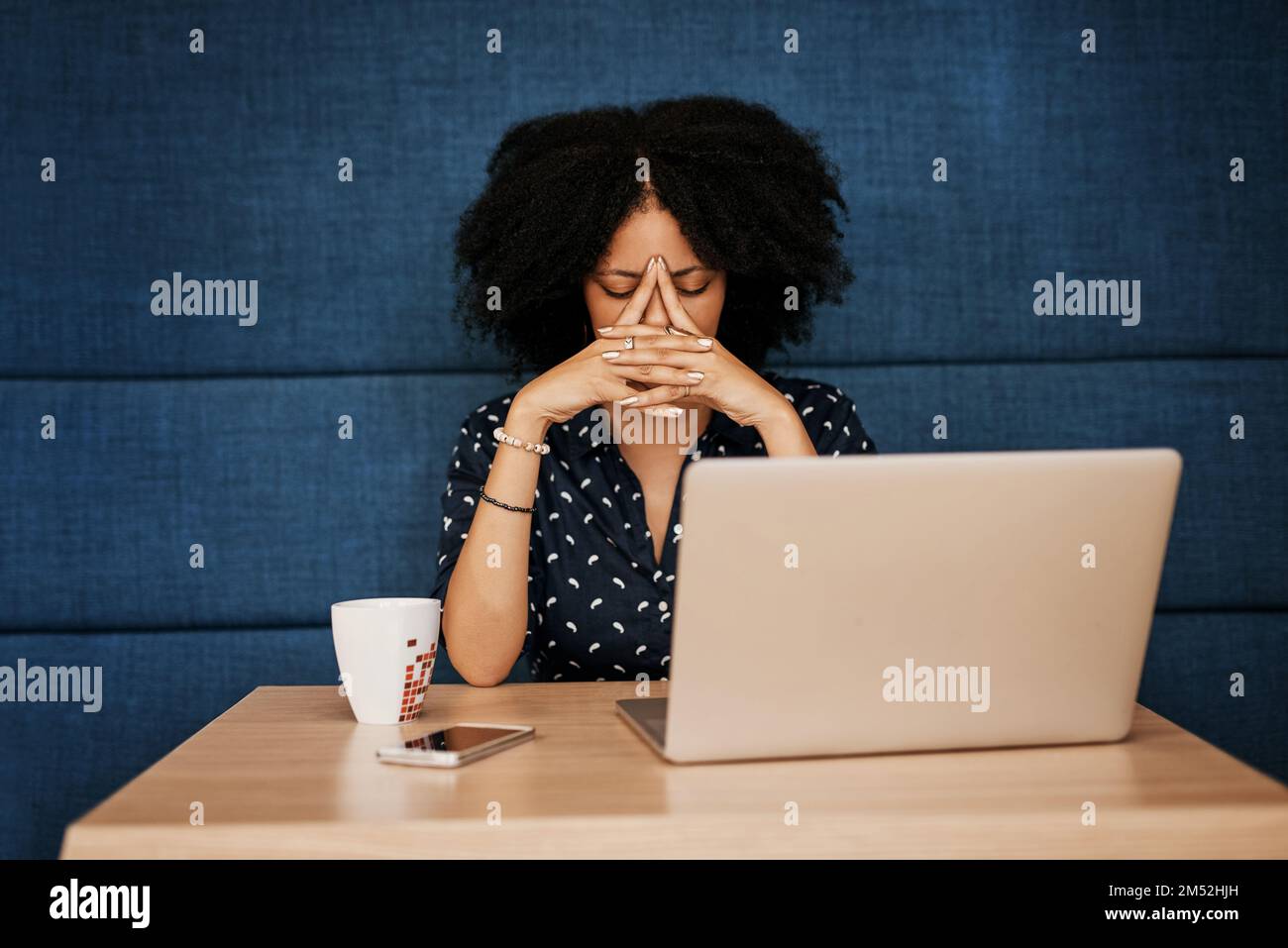 I have to think long and hard on this. a young female designer looking stressed while trying to work on her laptop at the office. Stock Photo