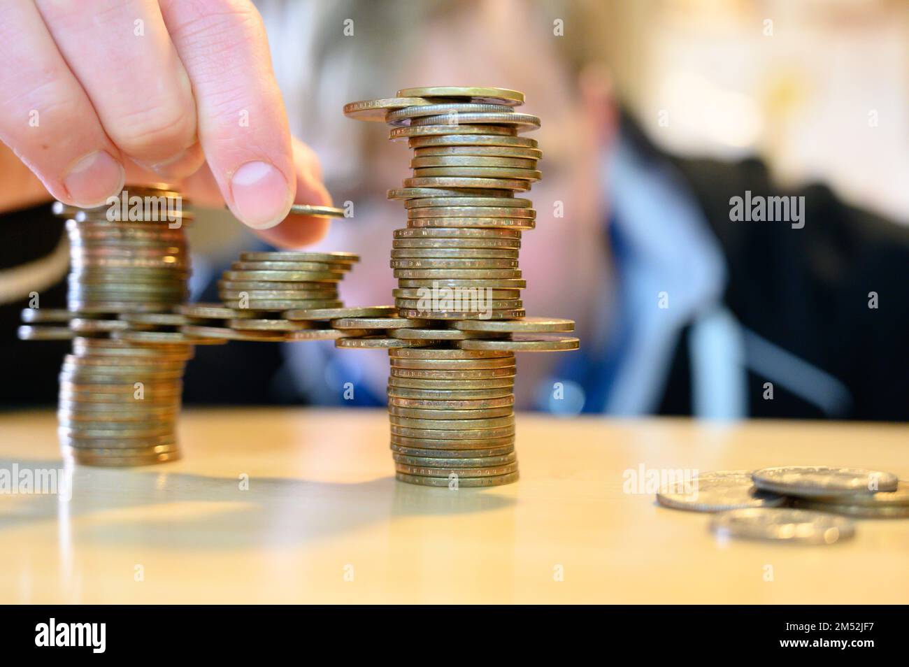 stacking gold dollar coins into bridge using a cantilever Stock Photo
