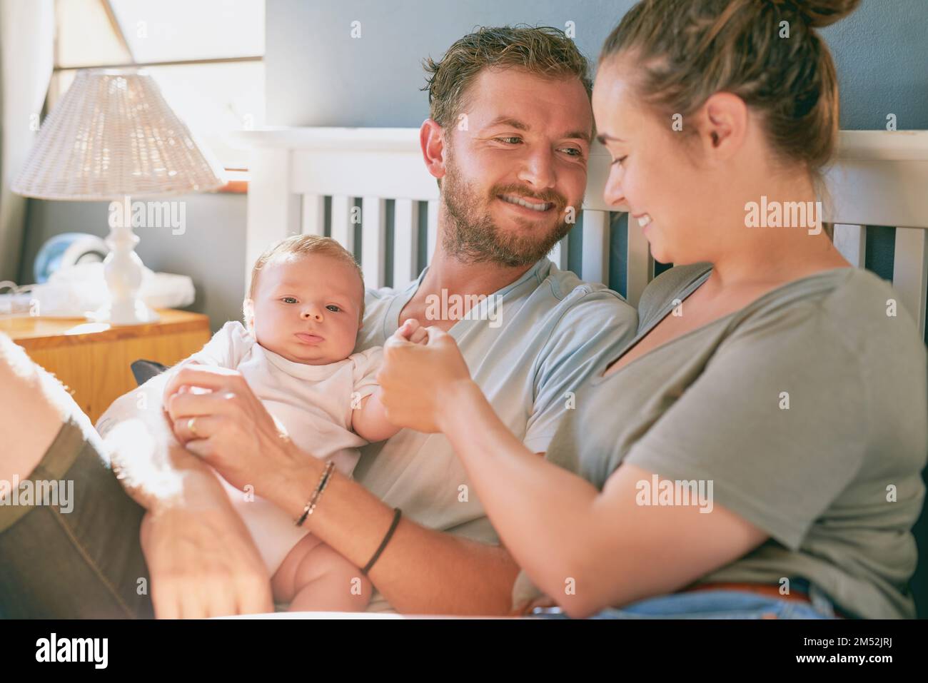 Shes such an amazing mom. a young mother and father bonding with their newborn baby boy in the bedroom. Stock Photo