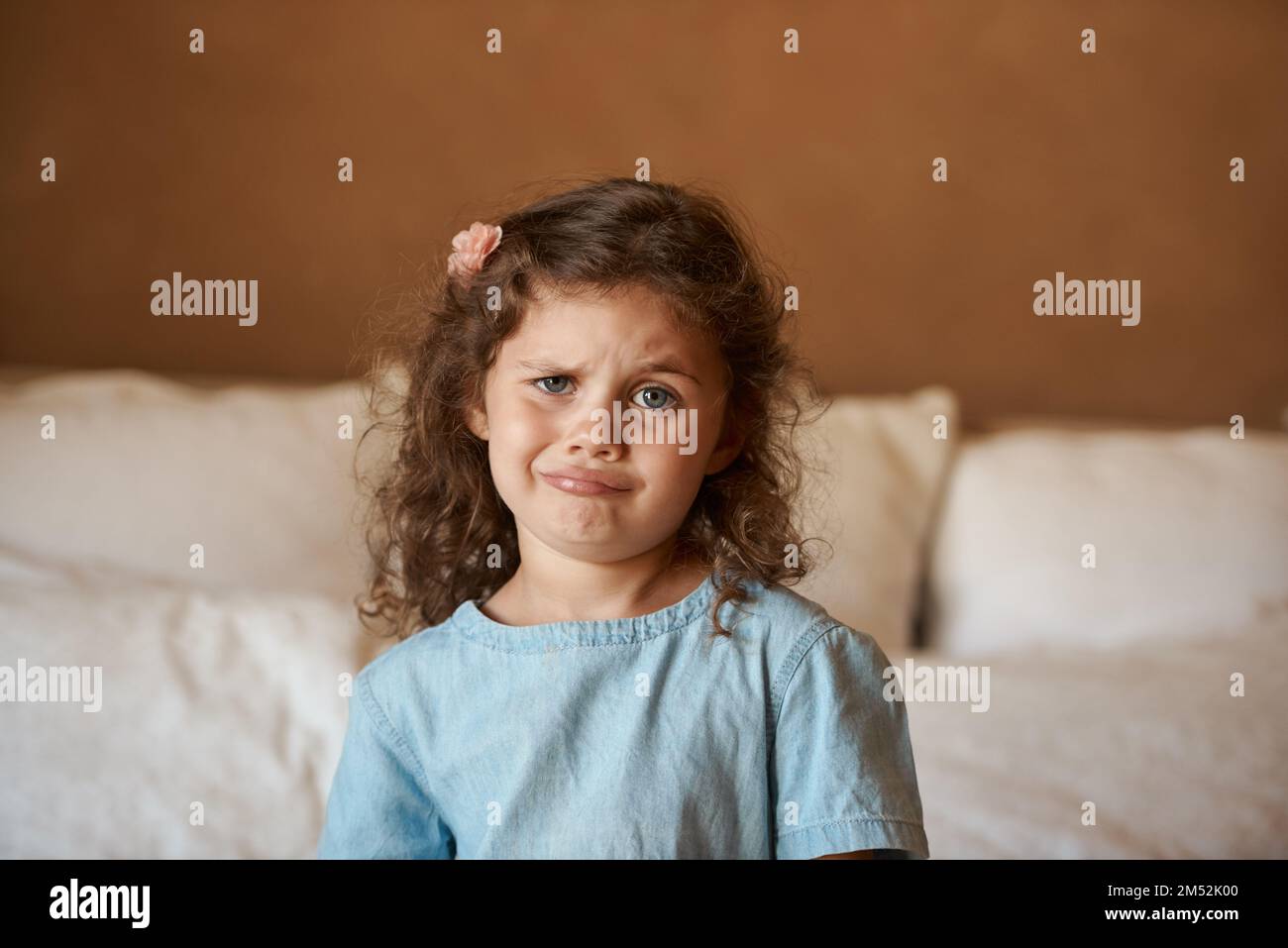 Im too old for coloring books mom. an adorable little girl at home pulling a weird but funny face. Stock Photo