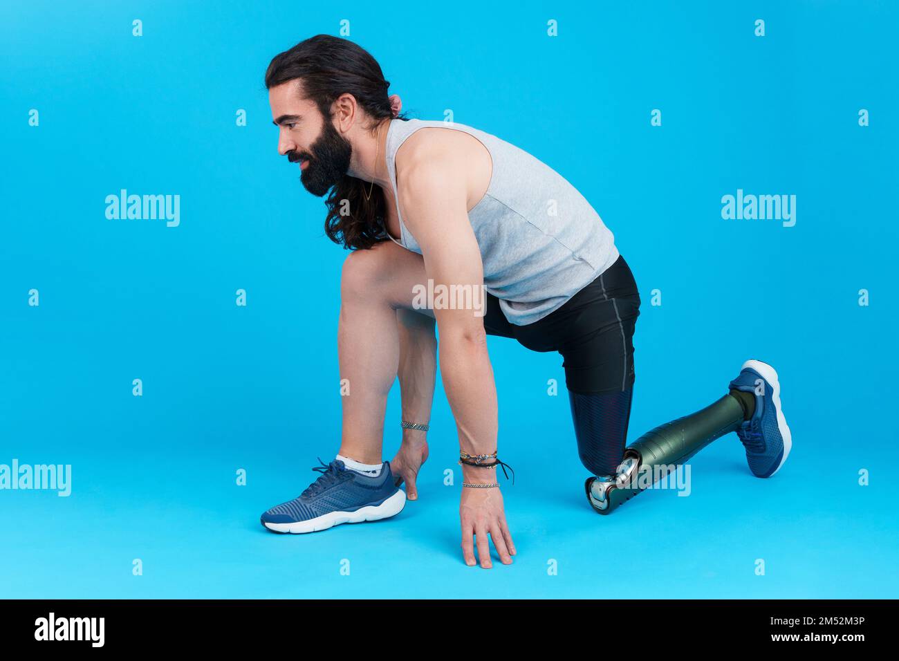 Man with amputated leg and prosthesis in sprinting position Stock Photo
