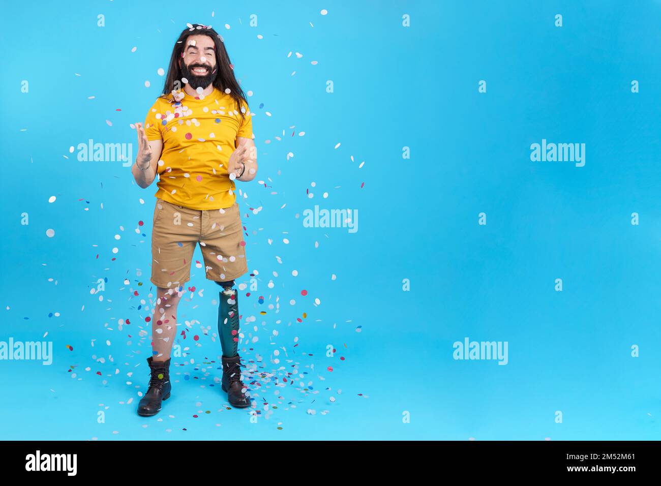 Happy man with a leg prosthesis surrounded by flying confetti Stock Photo