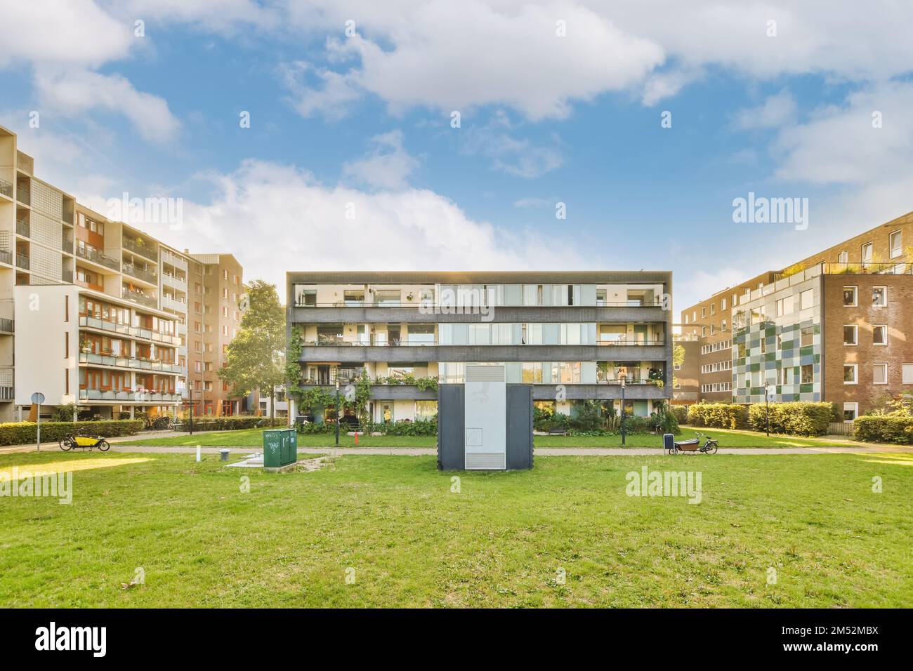 an apartment complex with green grass and trees in the foregrounding
