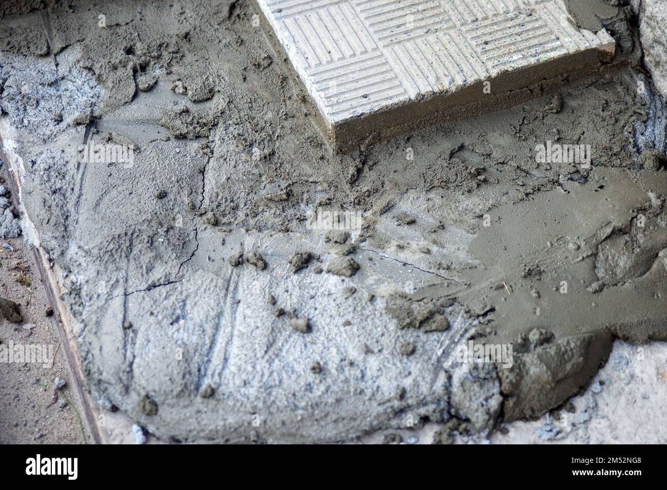 Closeup of liquid cement. Paving tile. Construction background. Pile
