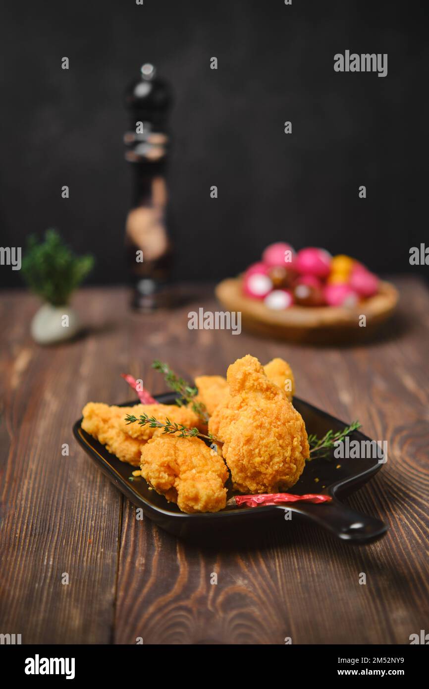 Selective focus photo of deep fried breaded chicken wings on shabby serving board Stock Photo
