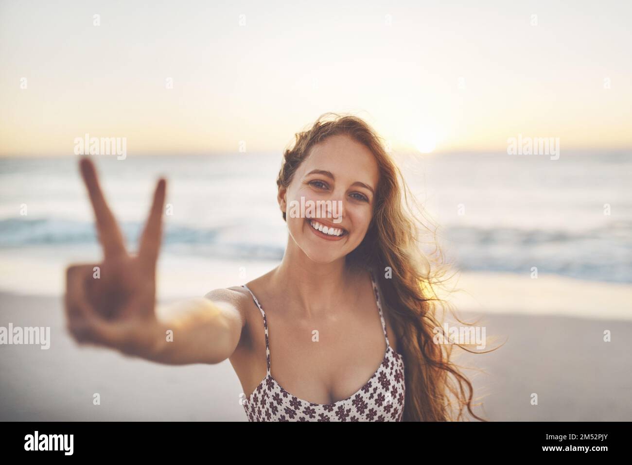 Youll find your peace at the beach. a woman showing the peace sign ...