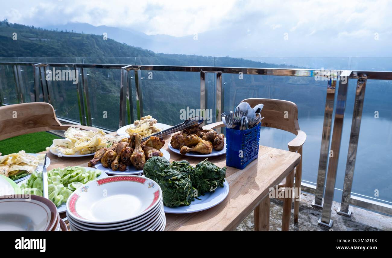 Landscape photo of food for breakfast in the morning over a beautiful lake with a mountainous background on the island of Java, Indonesia Stock Photo
