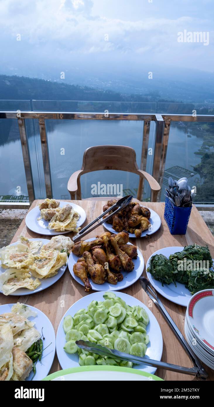 Portrait photograph of breakfast food taken over a beautiful lake with a mountainous backdrop on the Indonesian island of Java. Stock Photo