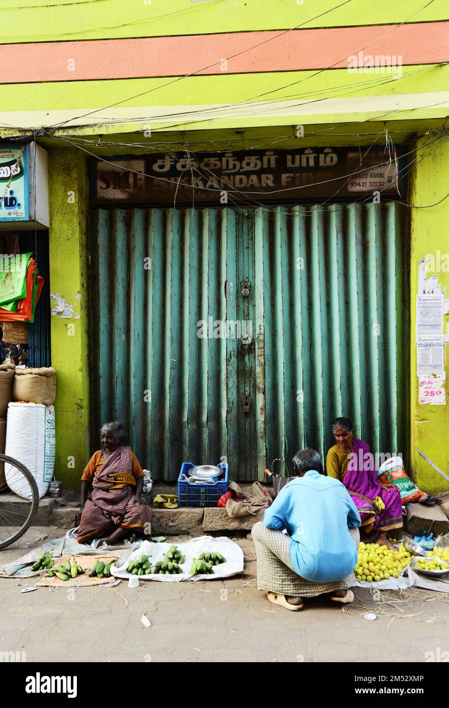 Tamil women selling bananas, Plantains and limes at a colorful street market in Madurai, Tamil Nadu, India. Stock Photo