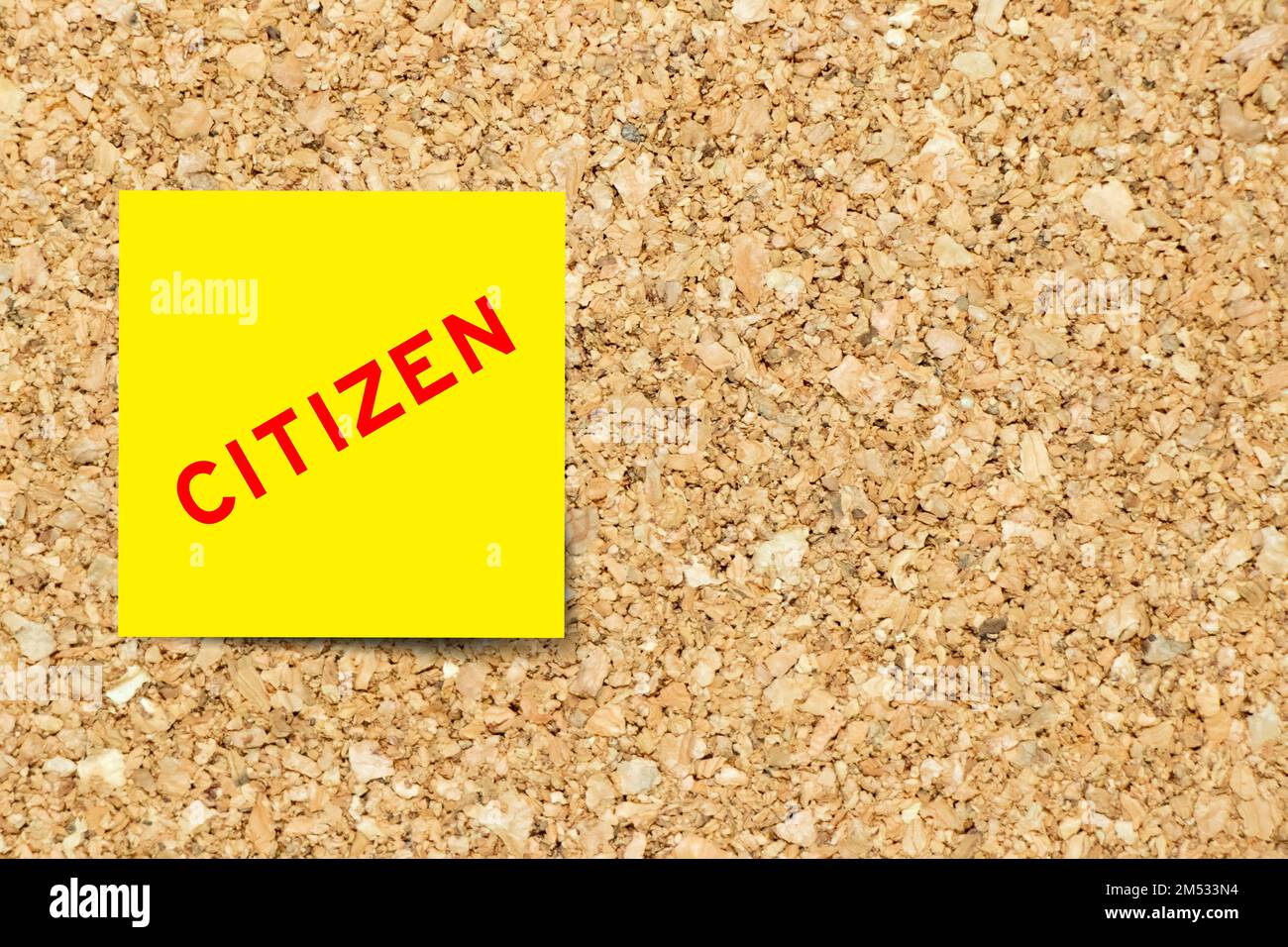 Yellow note paper with word citizen on cork board background with copy space Stock Photo