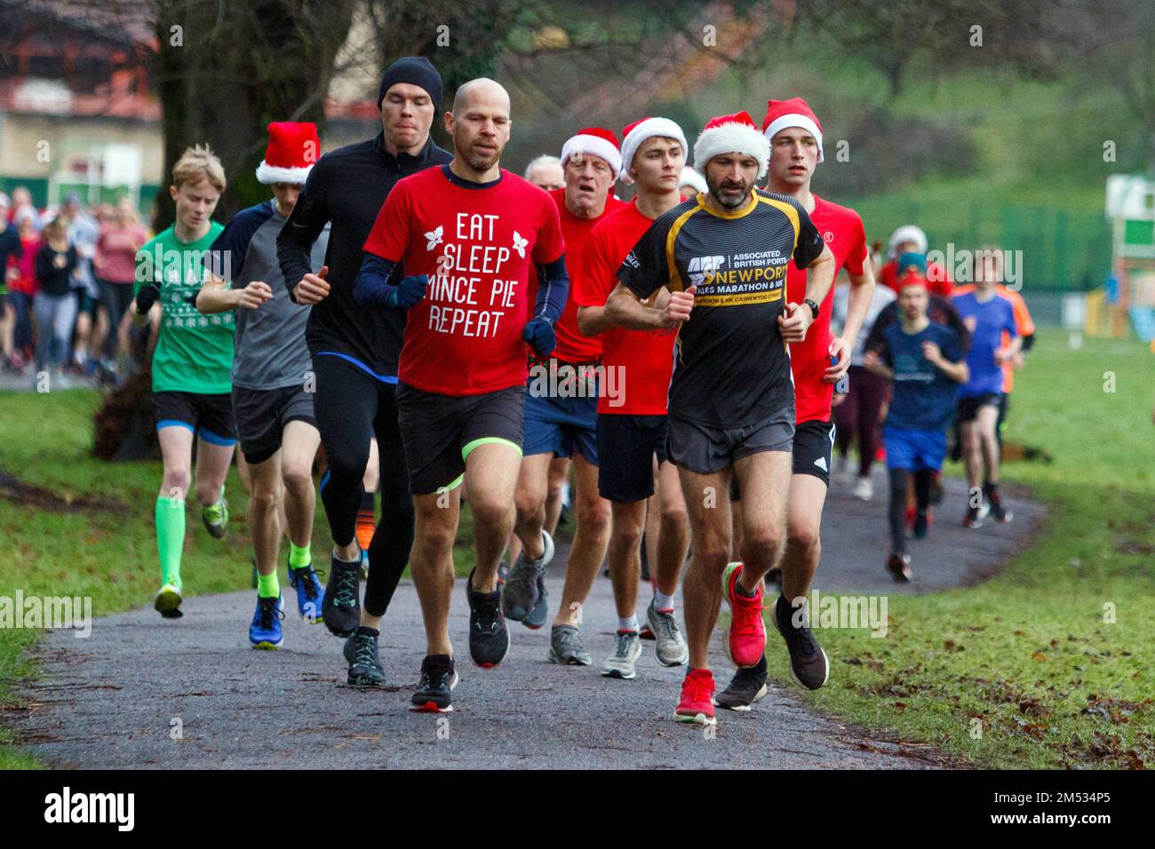 Chippenham, Wiltshire, UK. 25th December, 2022. Runners are pictured as they take part in an early morning Christmas day 5km park run in Monkton Park, Chippenham, Wiltshire. The wet weather did nothing to dampen the spirits of the 200-300 people who participated in the event with many of them dressing up in fancy dress. Credit: Lynchpics/Alamy Live News Stock Photo