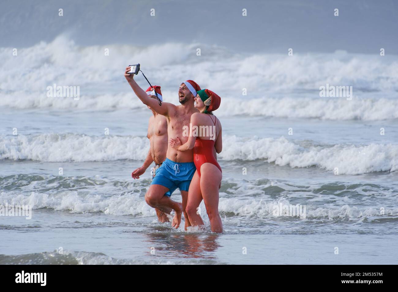 Polzeath, Cornwall, UK. 25th December 2022. UK Weather. Hundreds of people took to the sea at Polzeath this morning for the annual Christmas day swim. Credit Simon Maycock / Alamy Live News. Stock Photo
