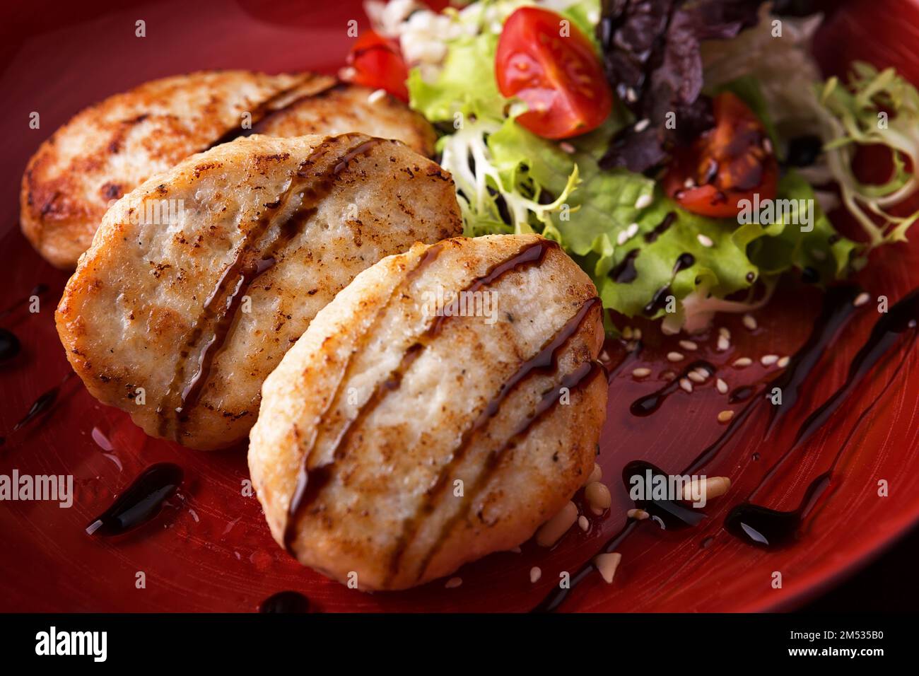 Steam cutlets with chicken on a plate with vegetables and salad Stock Photo