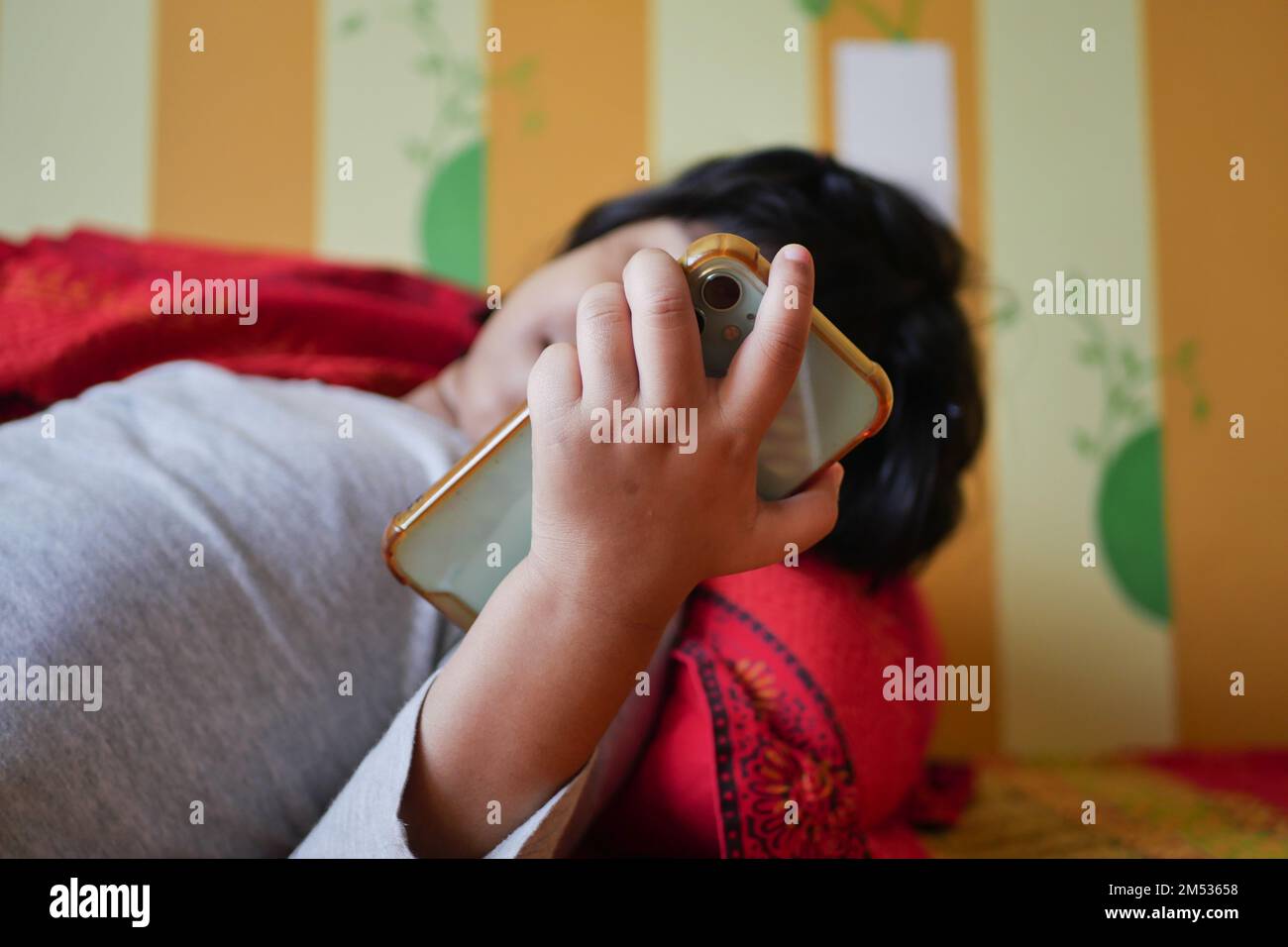 child using smart phone on bed  Stock Photo