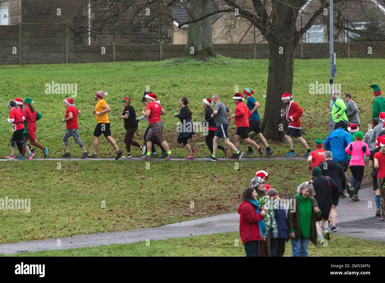 Chippenham, Wiltshire, UK. 25th December, 2022. Runners are pictured as they take part in an early morning Christmas day 5km park run in Monkton Park, Chippenham, Wiltshire. The wet weather did nothing to dampen the spirits of the 200-300 people who participated in the event with many of them dressing up in fancy dress. Credit: Lynchpics/Alamy Live News Stock Photo