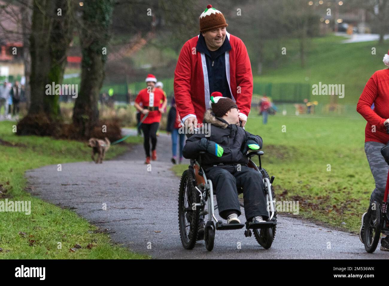 Chippenham, Wiltshire, UK. 25th December, 2022. People are pictured as they take part in an early morning Christmas day 5km park run in Monkton Park, Chippenham, Wiltshire. The wet weather did nothing to dampen the spirits of the 200-300 people who participated in the event with many of them dressing up in fancy dress. Credit: Lynchpics/Alamy Live News Stock Photo