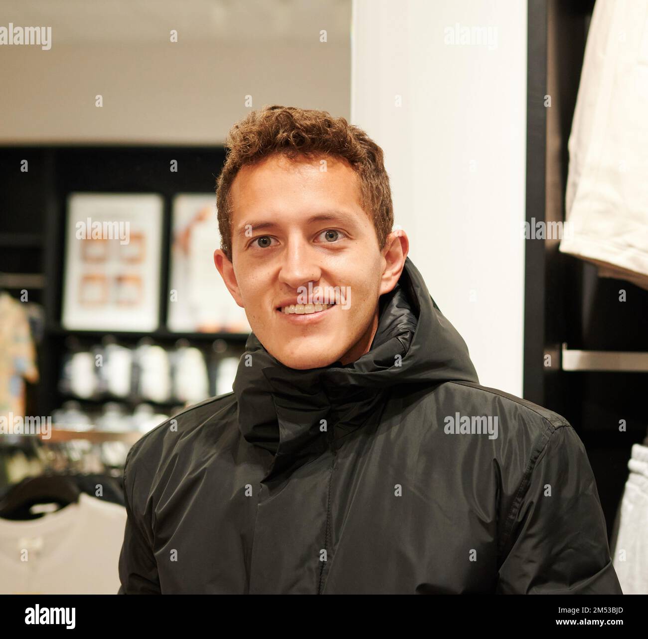 A closeup of a Caucasian man against the blurred background of a shop ...