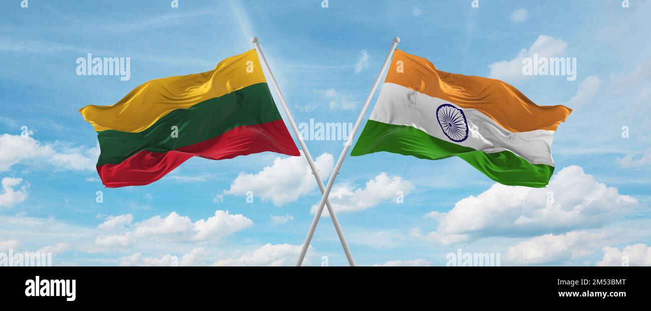 two crossed flags India and Lithuania waving in wind at cloudy sky ...