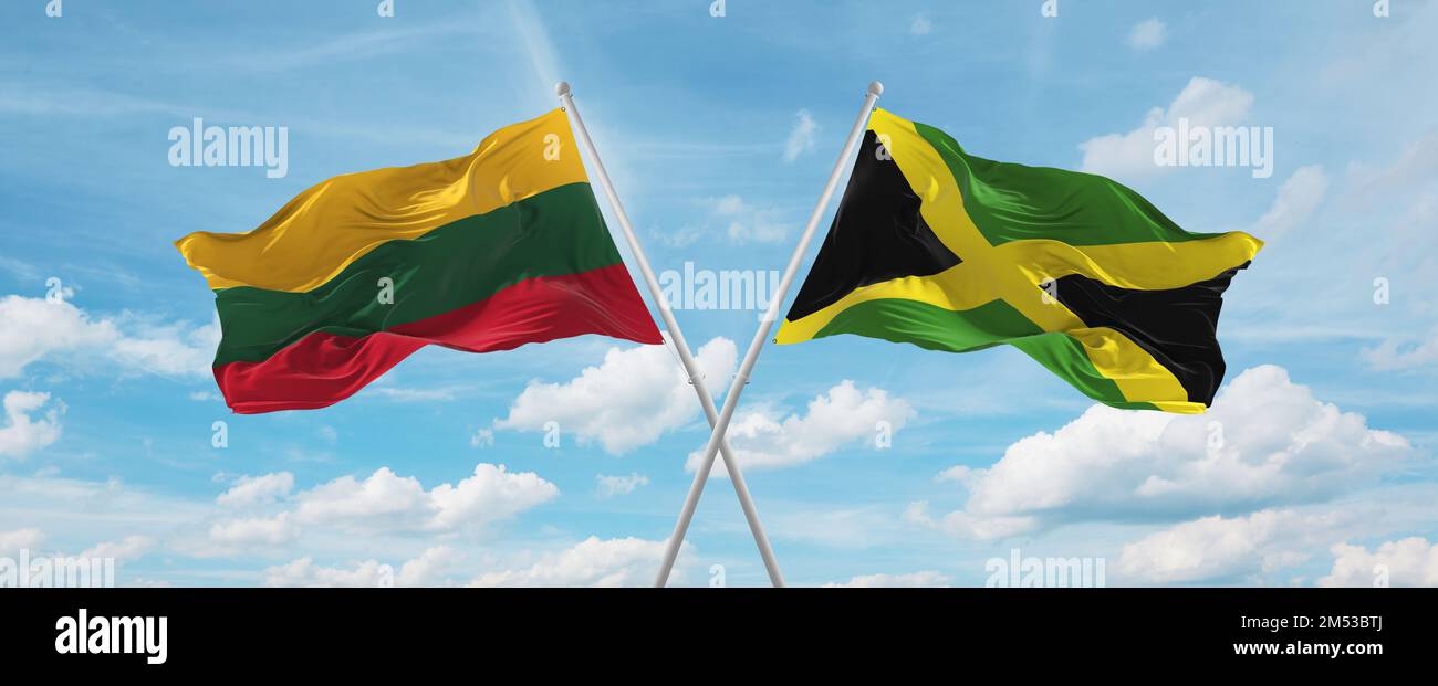 two crossed flags Jamaica and Lithuania waving in wind at cloudy sky ...