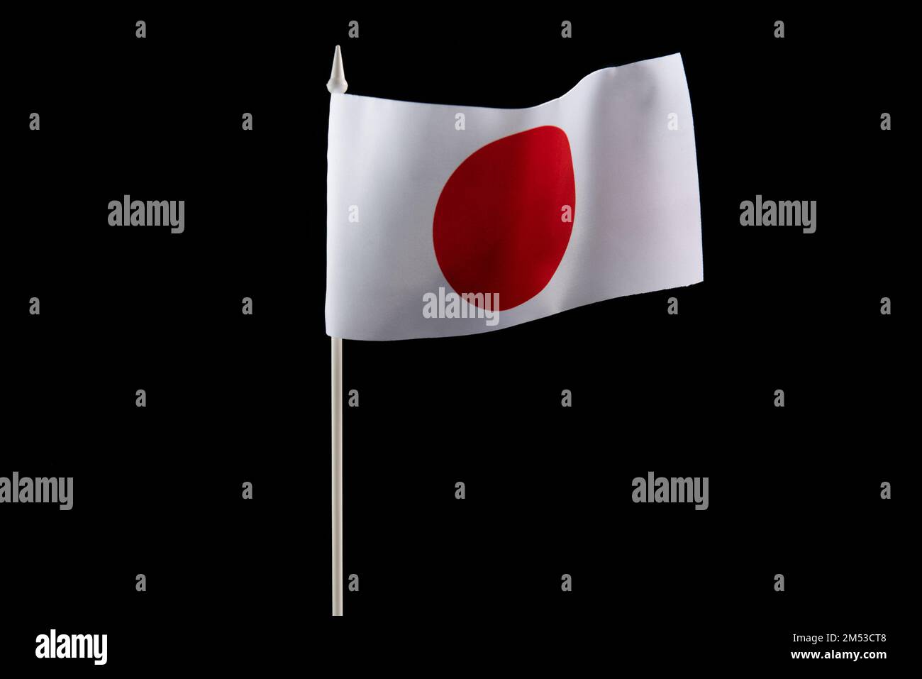 The Japanese flag on a black background developing and flying in the