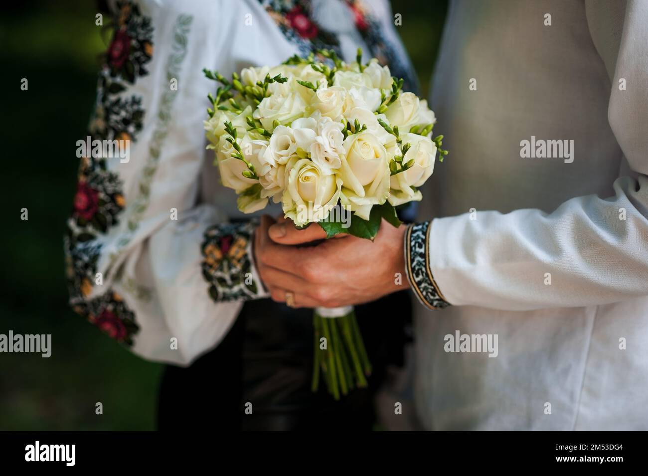 A bouquet of flowers in the hands of the bride. A bouquet of white flowers in the hands of a woman Stock Photo