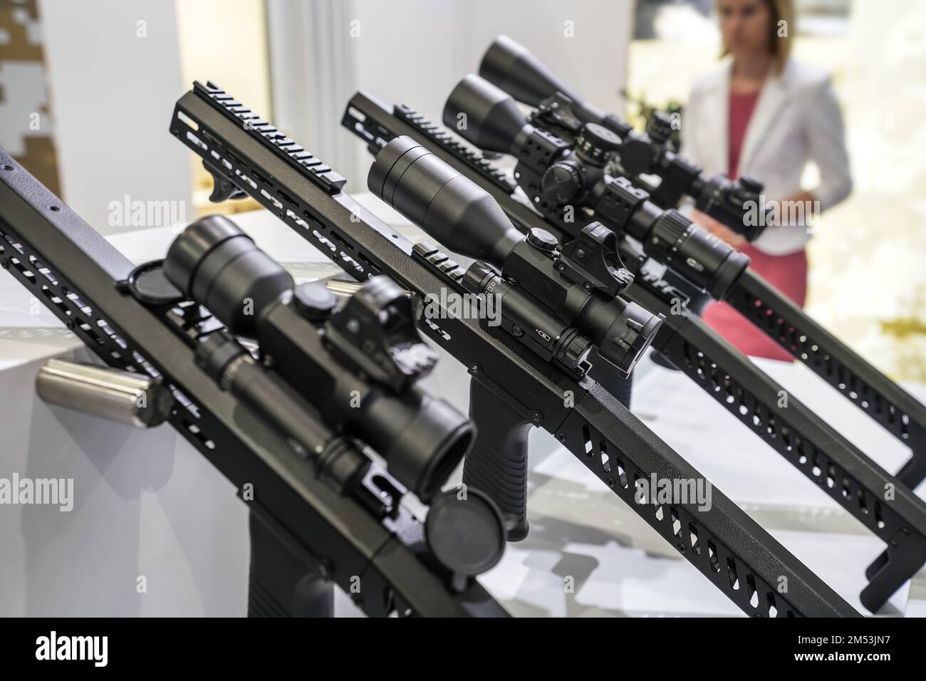 Black shooting scope optics mounted on metal bar displayed at weapons