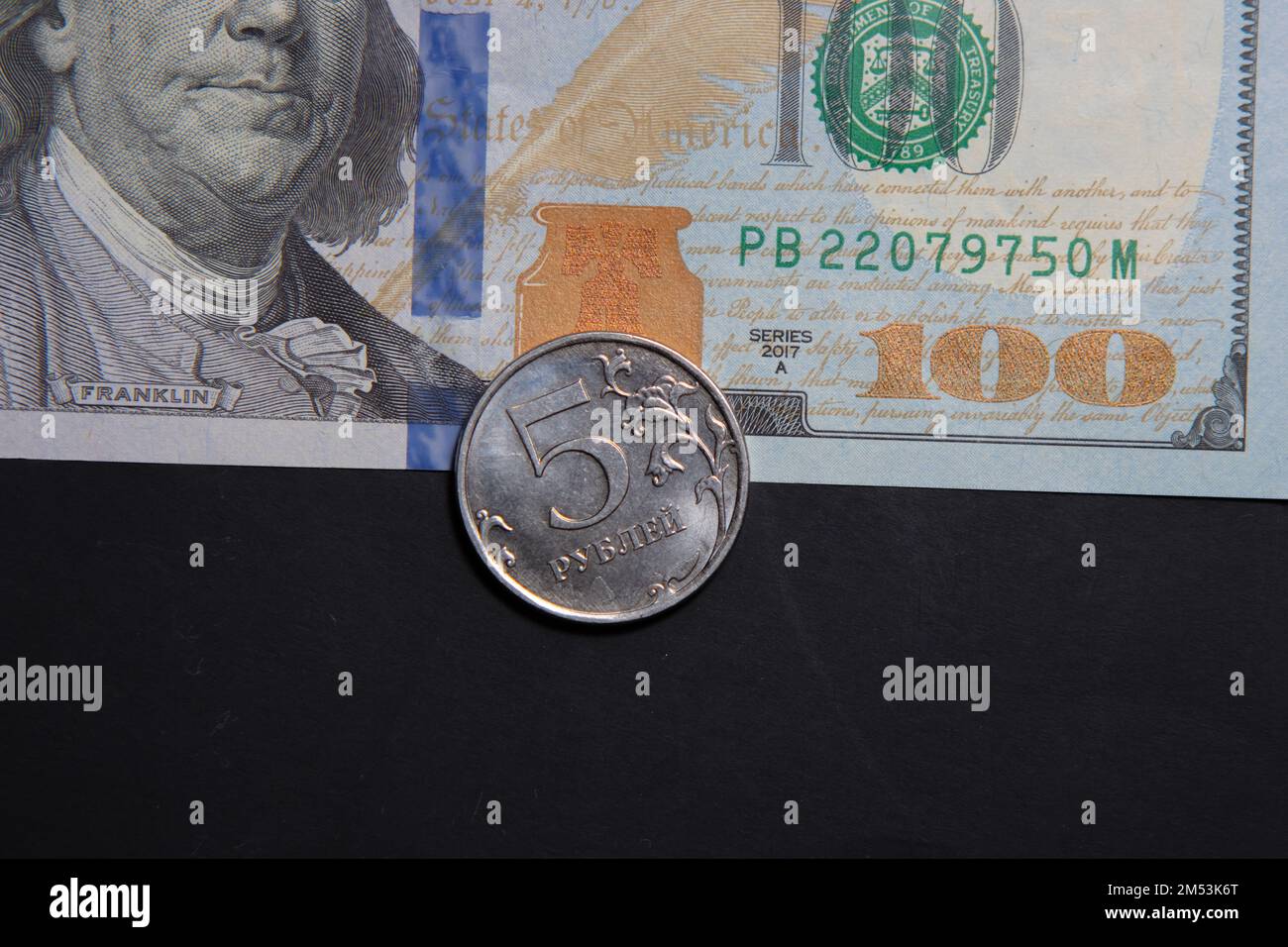 5 Russian ruble on a 100-dollar bill. The concept of the economic crisis. War rate dollar and ruble Stock Photo