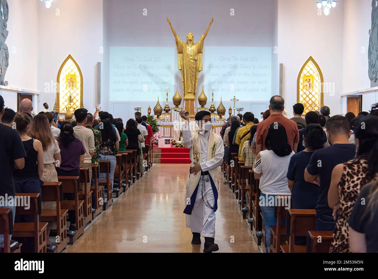 A Catholic priest seen sprinkling a holy water during the Christmas day mass at the Holy Redeemer Church in Bangkok. Stock Photo