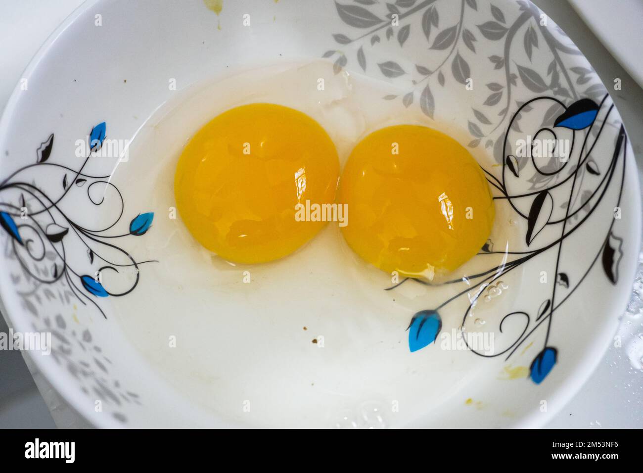 Two white and yellow yolk chicken eggs in a white bowl Stock Photo Alamy
