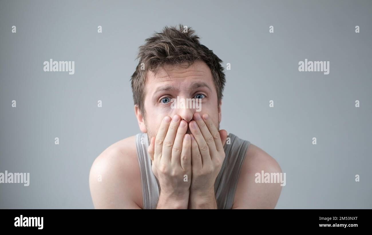 Scared caucasian guy shivering from fear, looking afraid and insecure