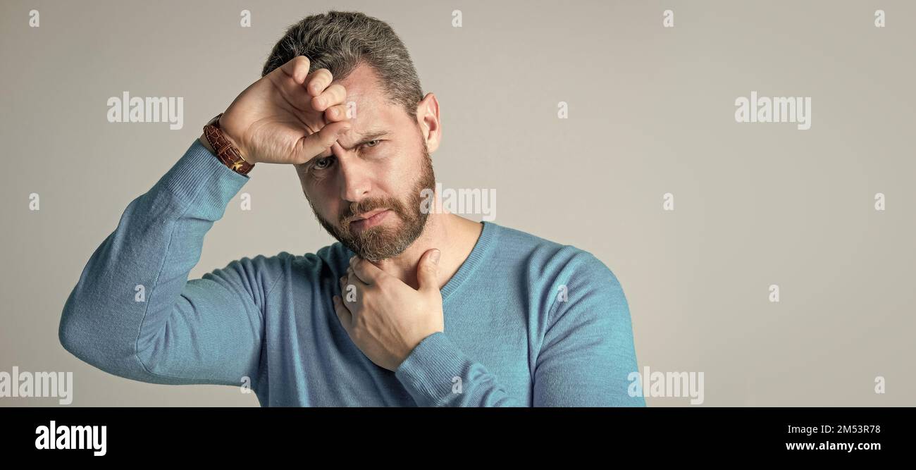 mature man with beard has heacache suffer from headahce on grey ...