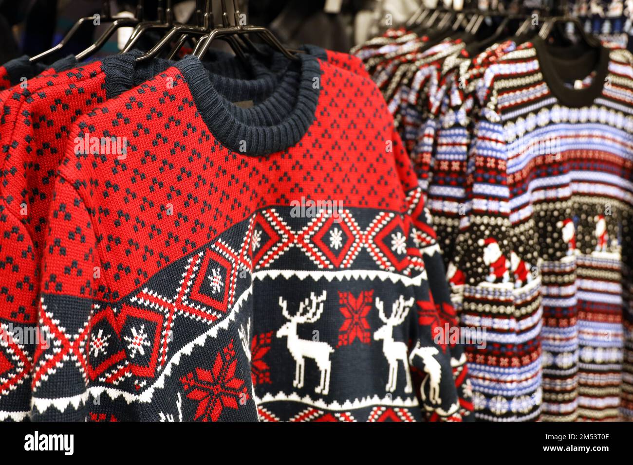 Knitted sweaters with Christmas pattern in a store. Traditional warm outfit for New Year holidays Stock Photo