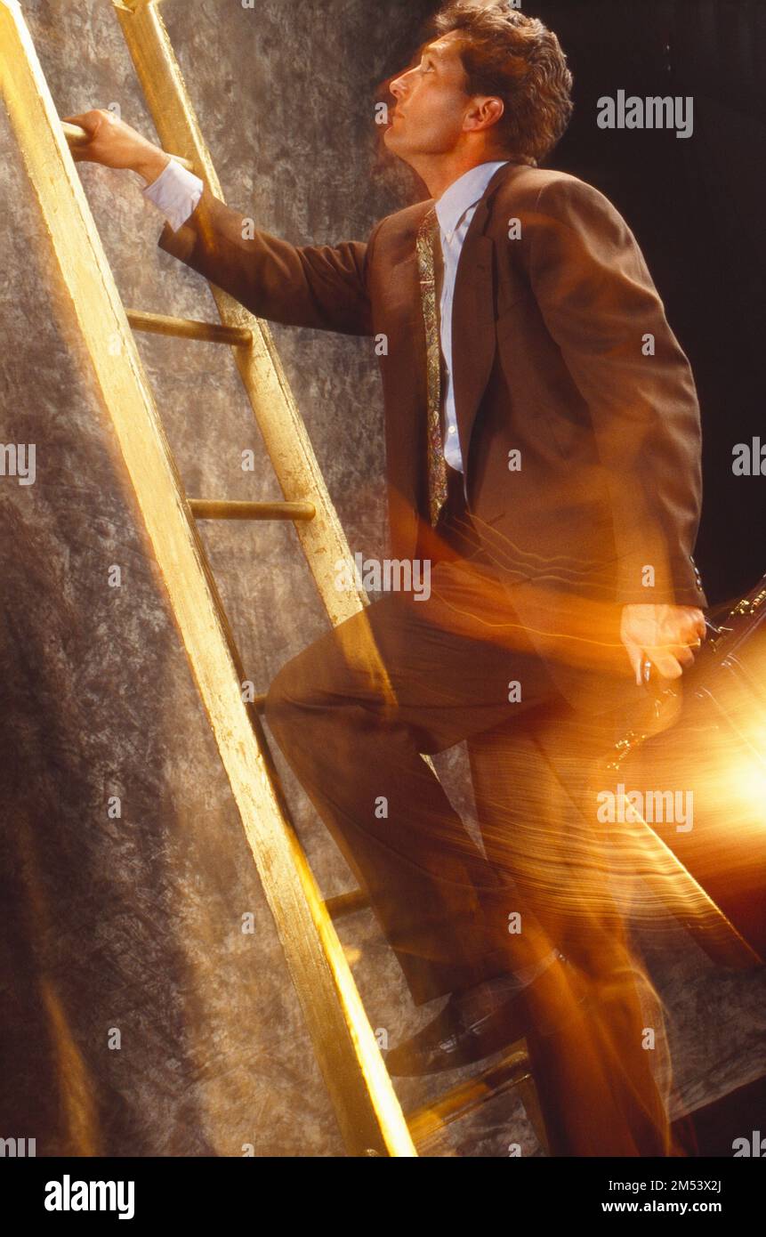 Symbolic shot of a businessman climbing a ladder with a briefcase
