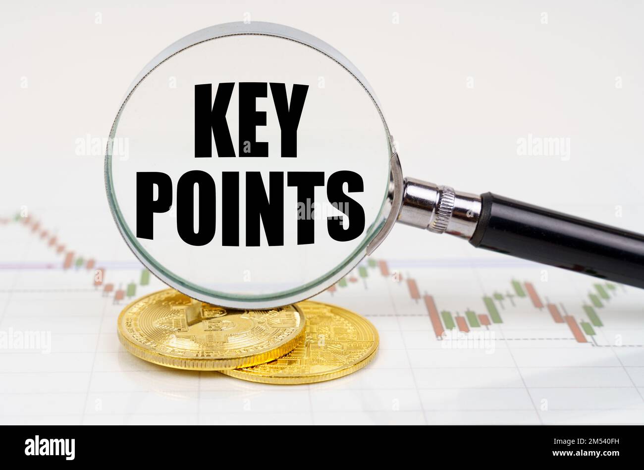 Business and technology concept. On the chart with quotes are bitcoins and there is a magnifying glass with the inscription - KEY POINTS Stock Photo