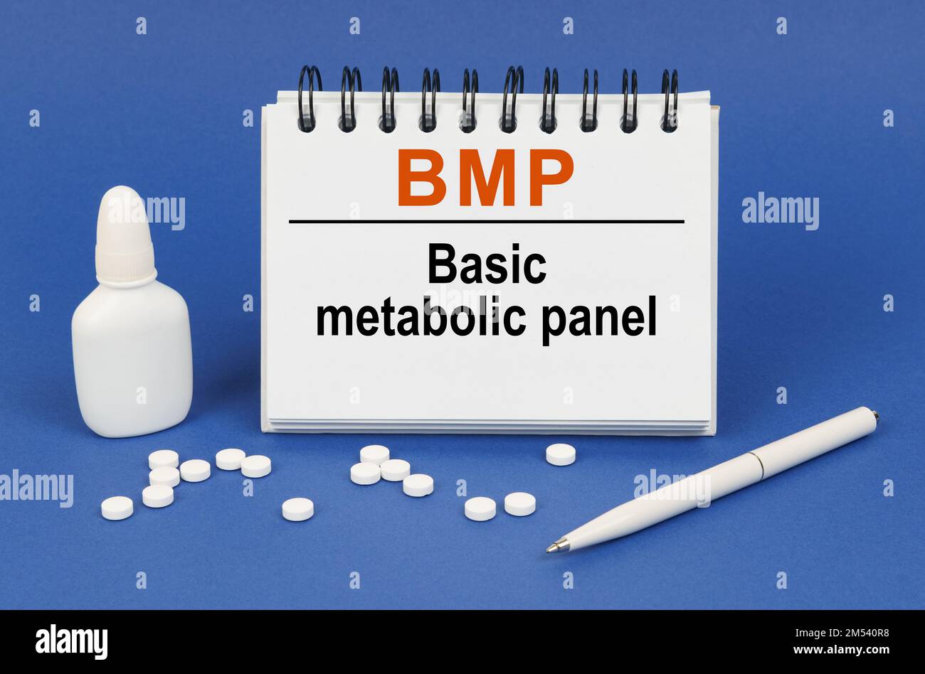 Medical concept. On a blue background, a pen, tablets and a notepad