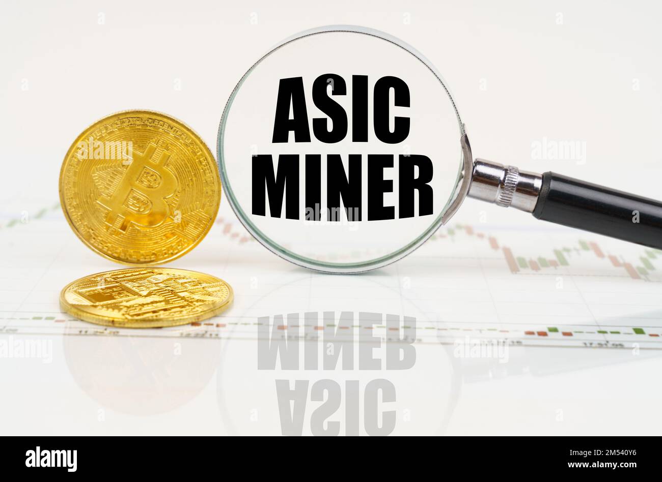 Business and technology concept. There are bitcoins on the chart and there is a magnifying glass with the inscription - Asic miner Stock Photo