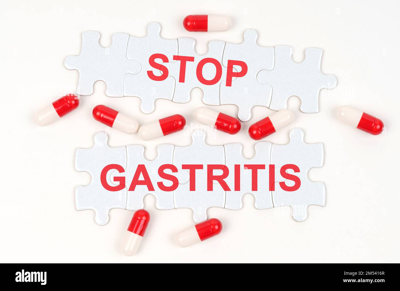 Medical concept. On a white surface, tablets and puzzles with the inscription - STOP GASTRITIS Stock Photo