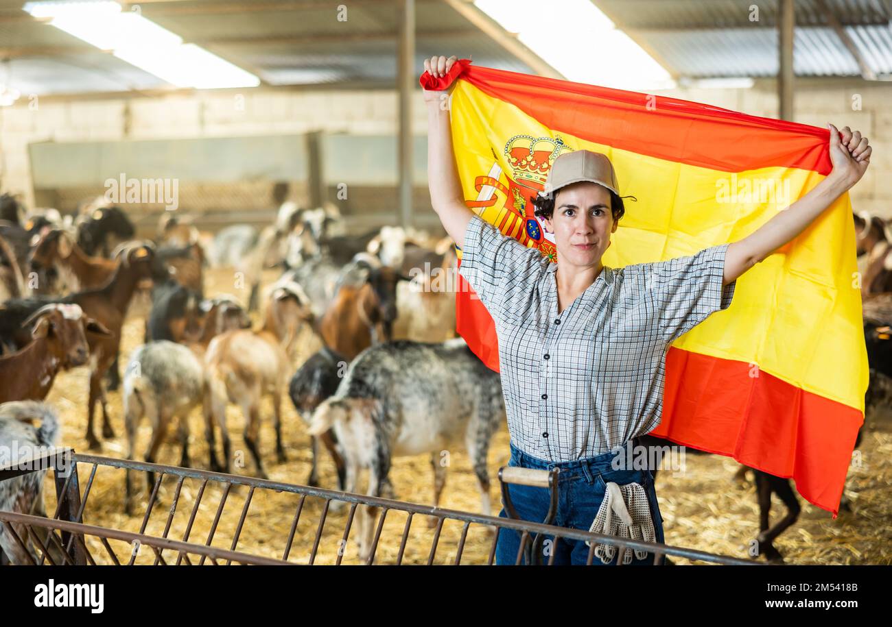 Portrait of happy female farmer with spanish flag in their hands in goat  pen Stock Photo - Alamy