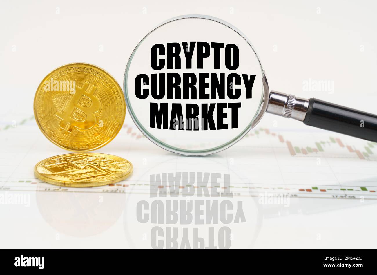 Business and technology concept. There are bitcoins on the chart and there is a magnifying glass with the inscription - Crypto currency market Stock Photo