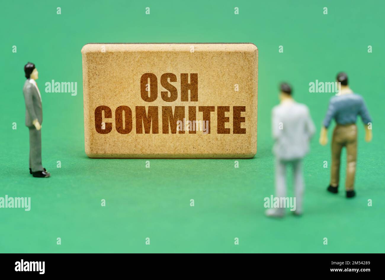 Security and insurance concept. On the green surface are figures of people and a sign with the inscription - OSH Commitee Stock Photo