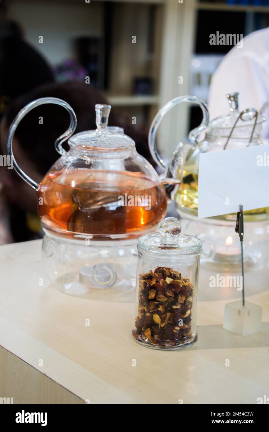 Herbal tea brewed in glass teapot and tea plant in a bottle Stock Photo