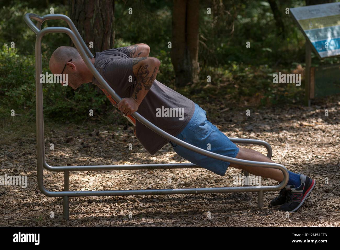Man doing push-ups on a trim trail, Bavaria, Germany Stock Photo