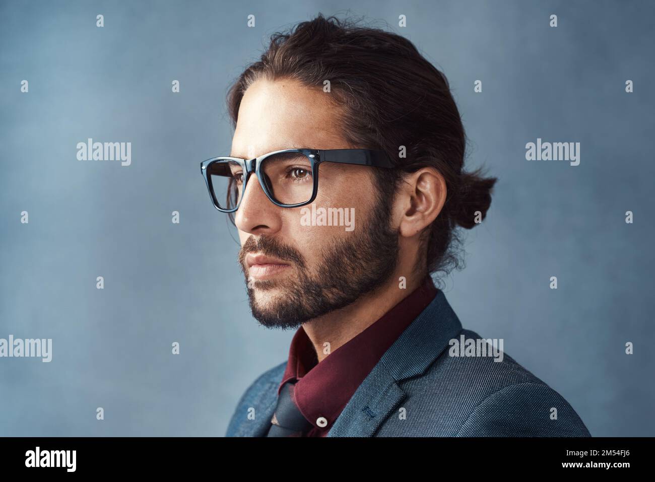 Clarity is key. Studio shot of a handsome young man looking thoughtful against a grey background. Stock Photo