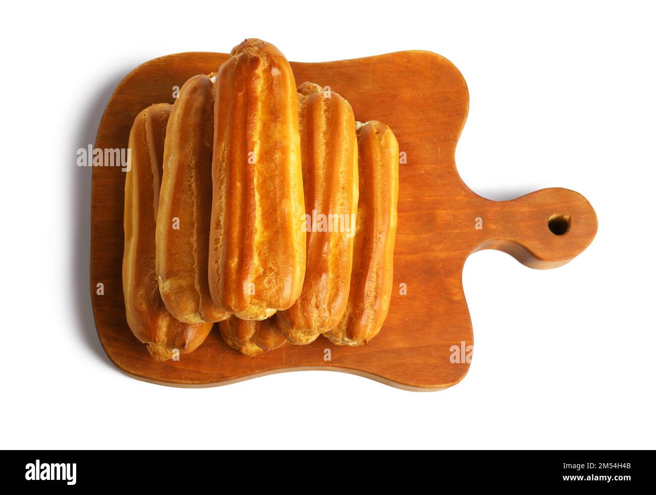 Wooden cutting board with tasty eclairs isolated on white background ...