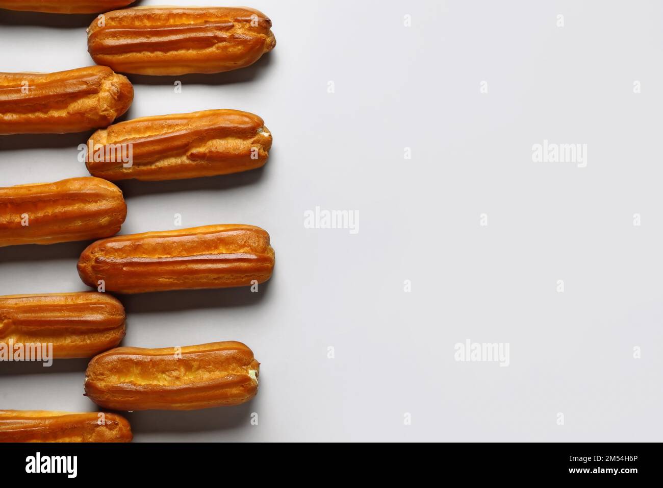 Composition with sweet eclairs on light background Stock Photo