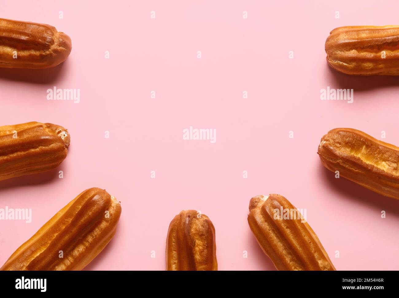 Composition with sweet eclairs on pink background Stock Photo