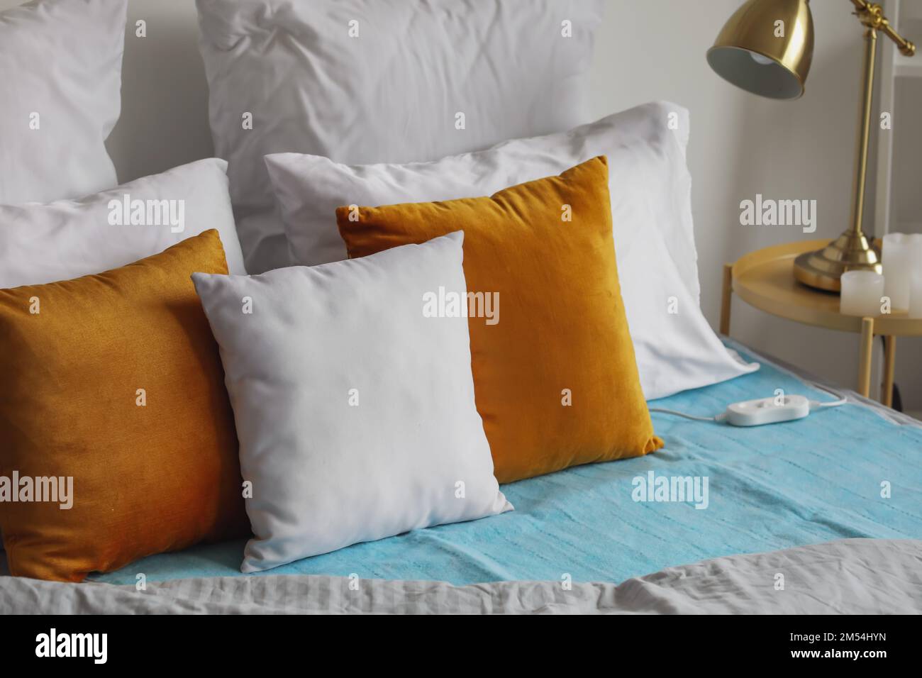 Bed with electric heating pad in bedroom Stock Photo